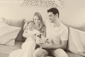 mom and dad with newborn baby and dog