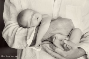 newborn baby sleeping in daddy's arms