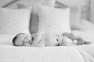 newborn child sleeping on parents' bed